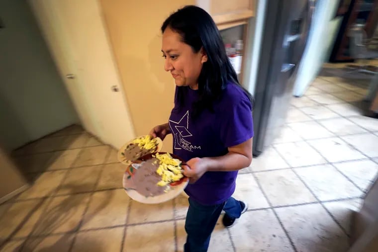 Karina Ruiz serves dinner at her home, Thursday, Nov. 7, 2019 in Glendale, Ariz.  Karina is in a program dating back to the Obama administration that allows immigrants brought here as children to work and protects them from deportation. The U.S. Supreme Court will hear arguments Tuesday, Nov. 12,  about President Donald Trump’s attempt to end the program, and the stakes are particularly high for the older generation of people enrolled in Deferred Action for Childhood Arrivals, known as DACA.