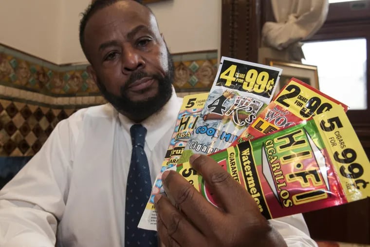 Councilman Curtis Jones Jr. holding packages of cigarillos packaged like candy.