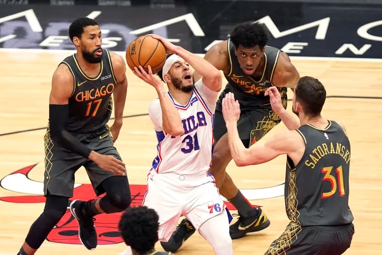 The 76ers' Seth Curry (31) drives to the basket as Chicago Bulls Garrett Temple (17), Tomas Satoransky (31) and Thaddeus Young defend during the second half.