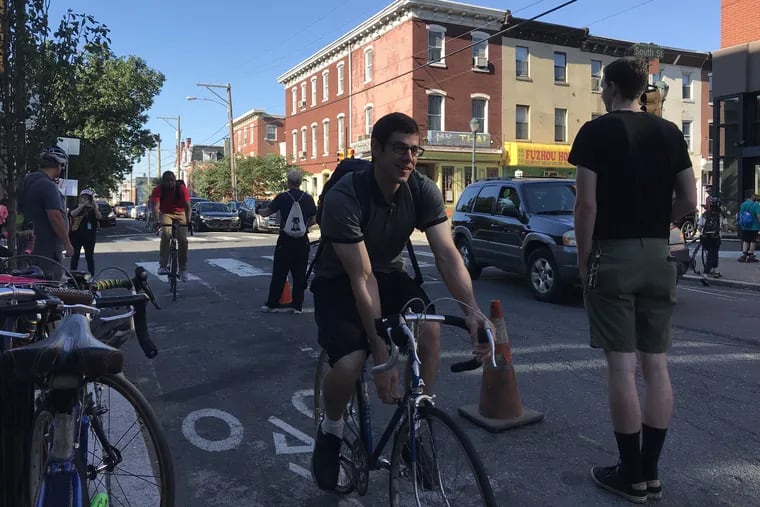 Cyclists pass demonstrators who lined the bike lane on 22nd Street between South and Lombard to draw attention to the poor condition of the street.