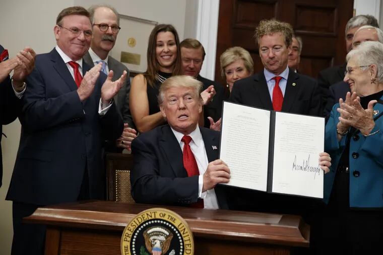 President Donald Trump shows an executive order on health care that he signed in the Roosevelt Room of the White House, Thursday, Oct. 12, 2017.