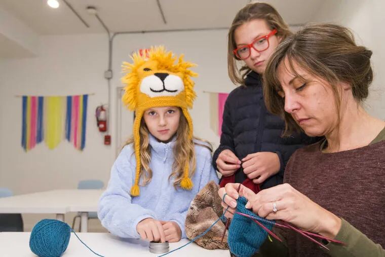 Jena Croxford (right) works on a fingerless mitten in the knitting 3 class at Loop.  Her daughters, Rodanthe, 9, (left) and Adon, 11 Croxford are also shown.