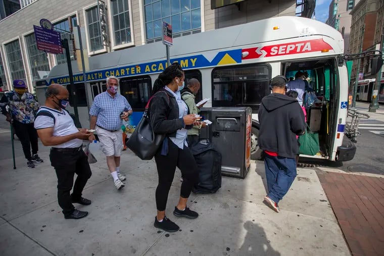 Riders board a bus Tuesday at 11th and Market Streets. SEPTA is increasing the capacity on its buses and trains as many pandemic restrictions are lifted.