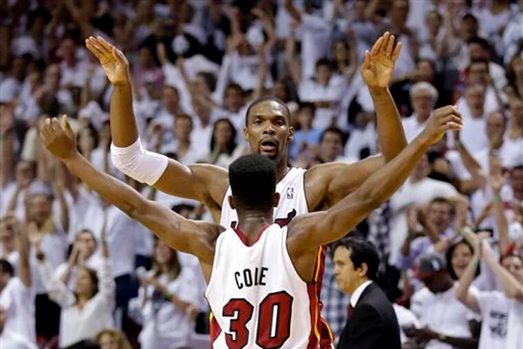 Miami's Chris Bosh and Norris Cole (30) celebrate after the Heat ended Chicago's season, 94-91, in Game 5.
 (Wilfredo Lee / AP)
