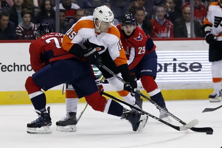 Flyers center Jori Lehtera (15), from Finland, controls the puck between Washington Capitals defensemen John Carlson (74) and Christian Djoos (29), from Sweden, during the second period of an NHL hockey game Wednesday, Jan. 31, 2018, in Washington.