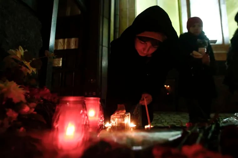 A woman lights a candle at a memorial in the main railway station in Volgograd, Russia, after two days of attacks in the city.