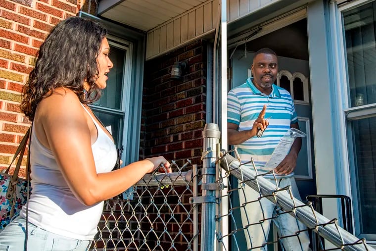 Keinalyse Medina (left), a canvasser with Community Marketing Concepts, a marketing consultant group contracted by the city's Department of Revenue, talks with Kevin Rozenblad (right) as she goes door-to-door in Ogontz.