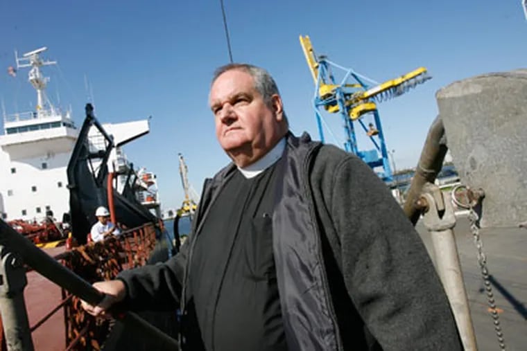 Father James Von Dreele boards the Tos Integrity at the Broadway Marine Terminal on the Camden waterfront. (Charles Fox / Staff Photographer )