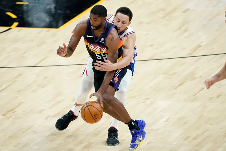 Sixers guard Ben Simmons reaching for the ball as Suns guard E'Twaun Moore (55) looks to pass during the second half Saturday.