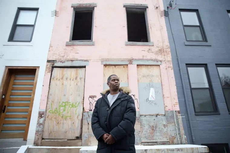Michael Dunn stands for a portrait outside the home at 1323 N. 27th St. in Philadelphia's Brewerytown section that was owned by his aunts Dorcas Moore and Harriette Dunn on Friday, Jan. 18, 2019. Dunn, who himself lived in the home for about 10 years until 1998, found out that the house was stolen by someone who forged a deed after his aunts died.