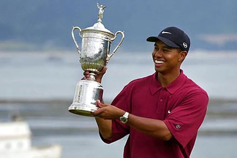 Tiger Woods shows off the winner's trophy after capturing the 100th U.S. Open Golf Championship at Pebble Beach in 2008. (AP Photo/Elise Amendola, File)