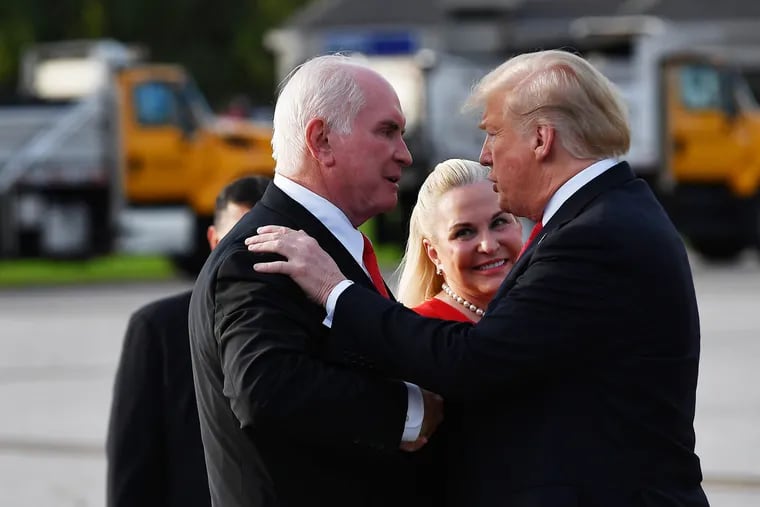 President Donald Trump greets U.S. Rep. Mike Kelly (R., Pa.), left, and his wife Victoria upon arrival at Erie International Airport in Erie, Pa., in 2018.