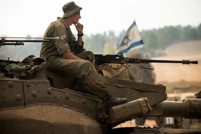 An Israeli soldier on a tank at the border. Premier Benjamin Netanyahu says the fighting won't end &quot;until the mission is completed to protect our citizens, soldiers, and children.&quot;