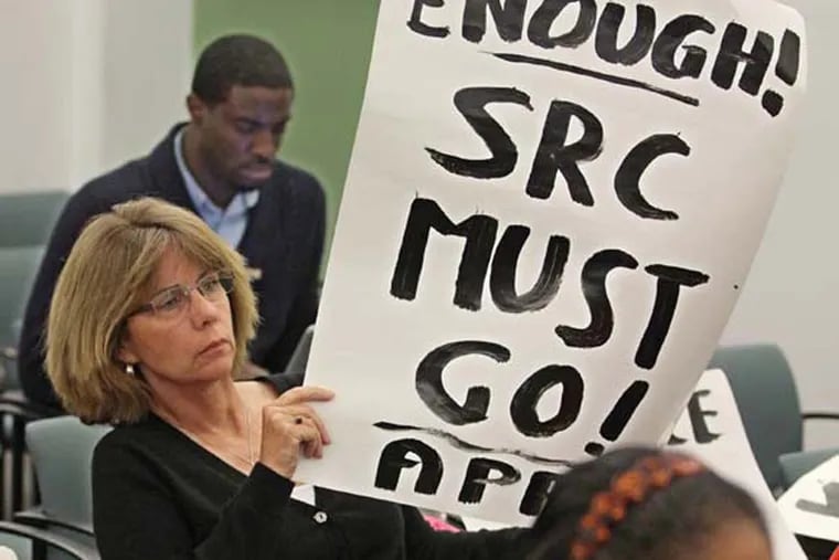 File: Lisa Haver, with Alliance for Public Schools, holds up a sign, expressing her views, at an April 2014 SRC budget meeting  (MICHAEL BRYANT / Staff Photographer )