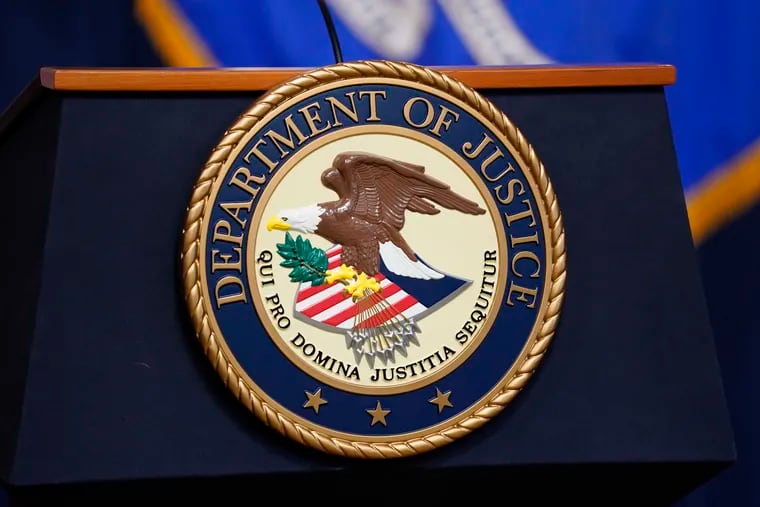 The seal for the U.S. Department of Justice is displayed on a podium in Washington last month. The U.S. Attorney in Philadelphia this month filed a False Claims Act lawsuit against James F. McGuckin, alleging that the Radnor physician collected at least $6.5 million for performing hundreds of medically unnecessary procedures from 2016 through 2019.