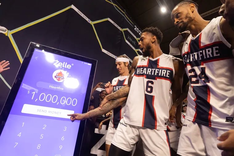 The Heartfire team, including Richard Solomon (center) and Raphael Solomon (right), pushing the "send money" button after winning the 2023 TBT title.