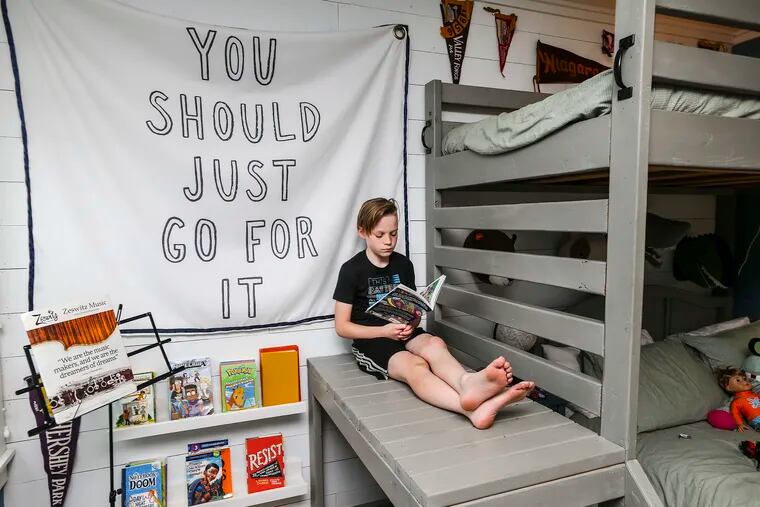 Blake Boehmke, 10, reads in the bedroom his mom, Lindsey, created as a DIY project at their Sellersville home. She built the bunk beds and created the reading nook and desk area.