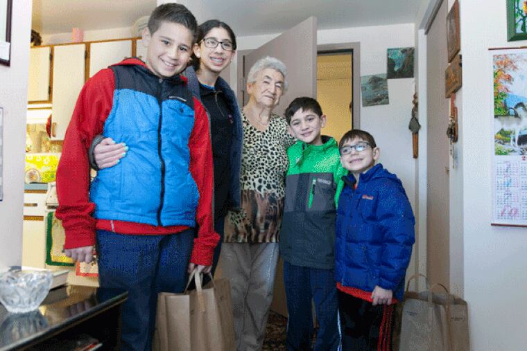On Sunday, Talia, Max and Joel Kepniss,  along with more than 300 Project H.O.P.E volunteers, delivered food boxes to resident of Saligman House, such as Feyga Karp (center), for Passover, which starts on Friday night.