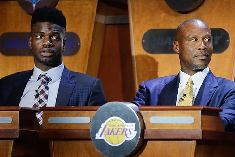 Los Angeles Lakers coach Byron Scott, right, and 76ers player Noel Nerlens listen as they find their teams in the top three spots for the draft during the NBA basketball draft lottery, Tuesday, May 19, 2015, in New York. (AP Photo/Julie Jacobson)