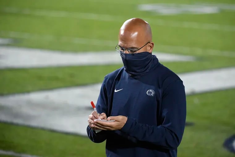 Penn State head coach James Franklin takes notes while leaving the field following Saturday's loss to Maryland.