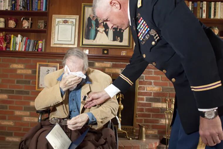 Vincent Benedict, who will turn 100 on July 4, is overcome by emotion in his Bryn Mawr home as Lt. Col. Jeffrey Voice applauds after pinning the Prisoner of War Medal to the WWII vet’s lapel. (Ed Hille / Staff Photographer)