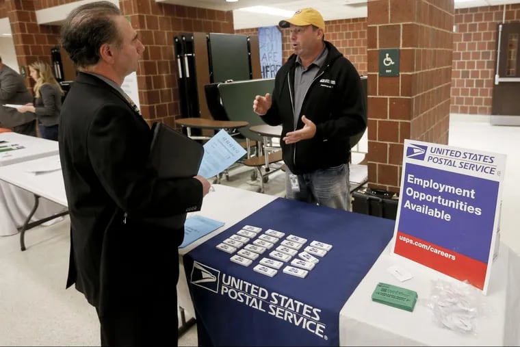 A recruiter from the postal service (right) speaks with an attendee of a job fair in Cheswick, Pa. on Nov. 2, 2017. Finding work after 50 has become difficult, especially for sales-related jobs.