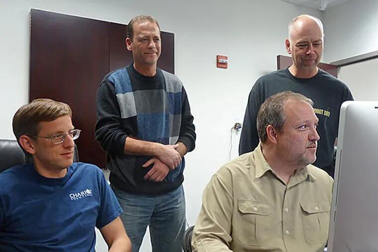 From the left are Aaron Mulder (seated), CEO Mike Rappaport (standing), Ken Rimple (at the computer) and Rod Biresch (standing) at Chariot Solutions. (Bob McGovern / Staff)