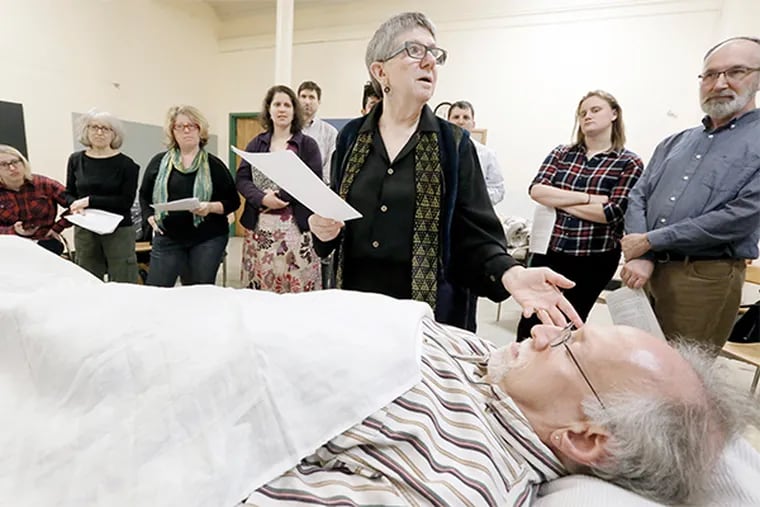 Rabbi Alan LaPayover plays the deceased person (in foreground) as Rabbi Linda Holtzman (top facing camera) teaches during the workshop at Calvary Center for Culture and Community in Phila. on Feb. 28, 2016.