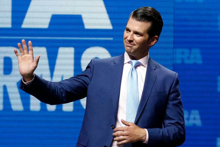 Donald Trump Jr. waves from the stage at the National Rifle Association in Dallas.