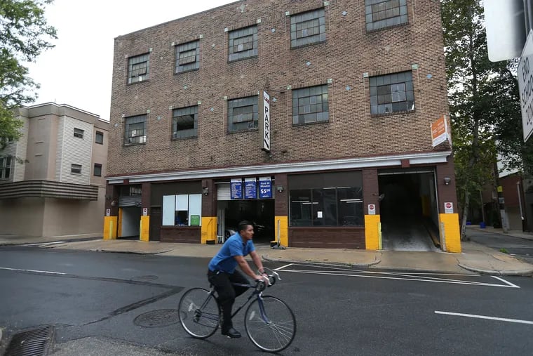 A cyclist passes in front of a parking garage at 16th and Addison streets in Philadelphia, PA on August 29, 2017. The garage is set for demolition to make way for townhouses.