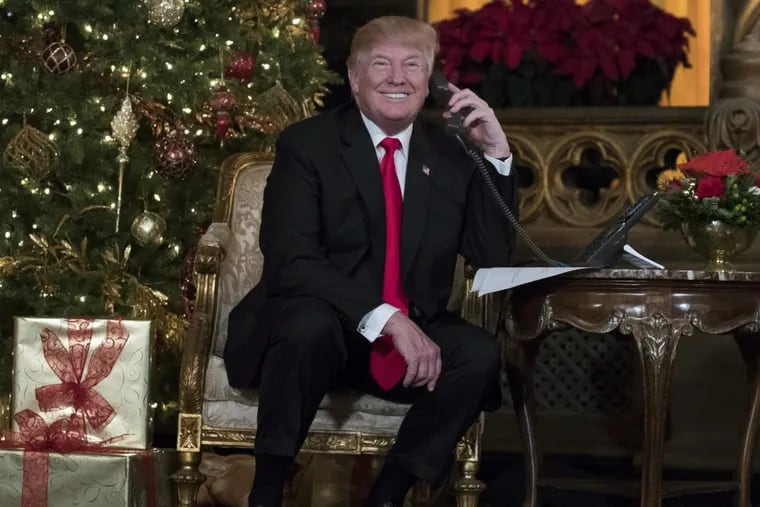 President Donald Trump smiles to the media as he speaks on the phone with children as they track Santa's movements with the North American Aerospace Defense Command (NORAD) Santa Tracker on Christmas Eve at the president's Mar-a-Lago estate in Palm Beach, Fla., Sunday, Dec. 24, 2017. (AP Photo/Carolyn Kaster)