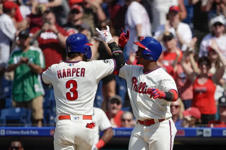 Philadelphia Phillies' Bryce Harper celebrates with Jean Segura after hitting a home run with one run batted in during the sixths inning of a baseball game Sunday, May 19, 2019, in Philadelphia. The Phillies won 7-5. (AP Photo/Matt Rourke)