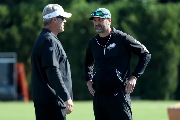 Eagles head coach Doug Pederson (left) and offensive coordinator Mike Groh talk during Eagles training camp.