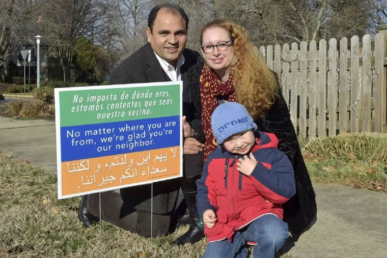 Yousaf Chaman, Jenni Leister, and son Nouraiz in their front yard in Lancaster. As political rhetoric heated up, other churches and people asked how they could obtain the signs from the Rev. Matthew Bucher of Immanuel Mennonite Church in Harrisonburg, Va.