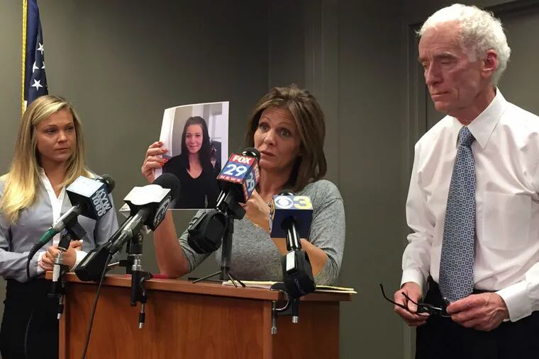 Joanne DeGuio holds up a picture of her daughter Amanda as Amanda's sister Nicole looks on at left. Upper Darby police Superintendent Michael Chitwood is at right.