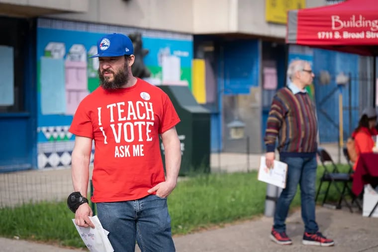 Election day volunteer Andrew Saltz, a teacher at Paul Robeson High School, hands out voting stickers at the Ford PAL Recreational Center in South Philadelphia.