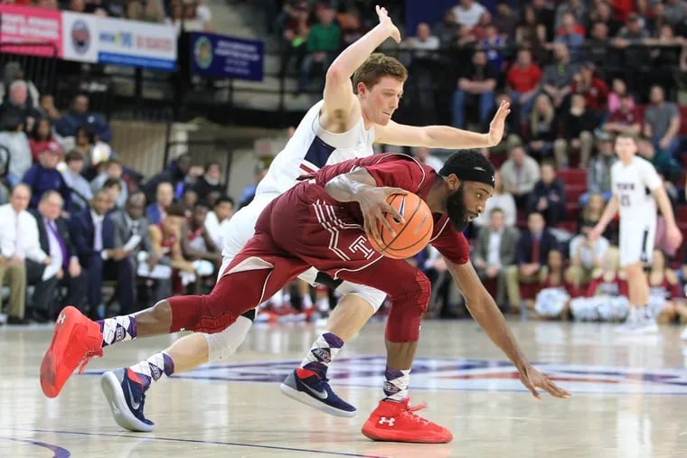 Josh Brown, bottom, of Temple driving up the court against the pressing defense of Jake Silpe of Penn on Jan. 20.