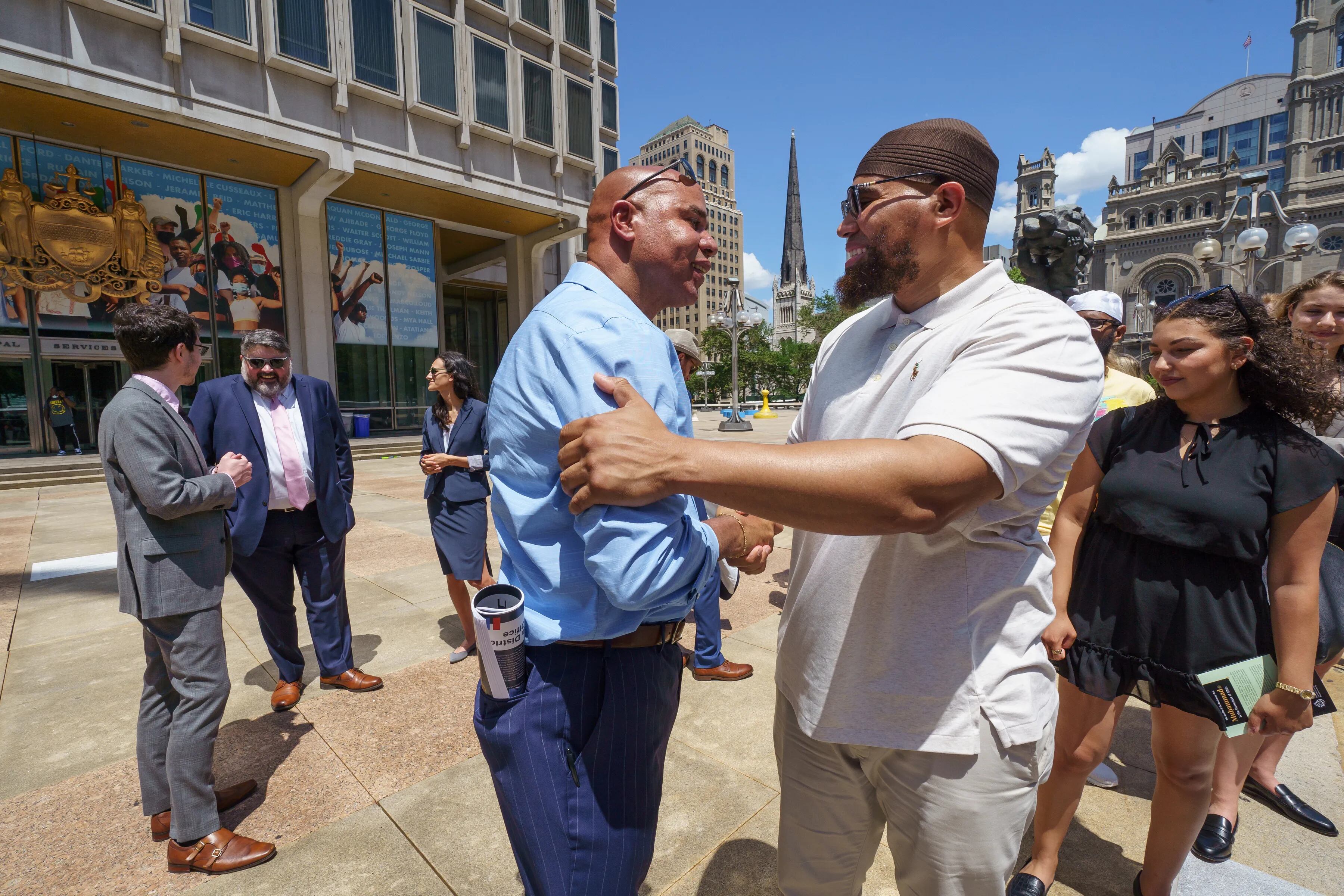 Andrew Swainson, left, and Terrance Lewis,  both exonerated, greet each other after a news conference about a report detailing the work of the Conviction Integrity Unit on June 15, 2021.