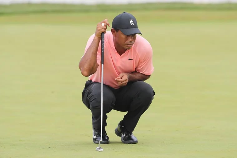 Tiger Woods lines up a putt on the 18th hole at Aronimink.