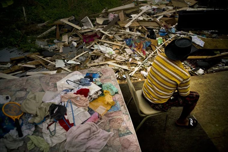 Efrain Diaz Figueroa spends the afternoon sitting on a chair next to the remains of the house of his sister destroyed by Hurricane Maria in San Juan, Puerto Rico, Monday, Oct. 9, 2017. Figueroa, who was visiting for a month at her sister Eneida’s house when the Hurricane Maria hit the area, also lost her home in the Arroyo community. He waits for a relative to come and take him to Boston. He says that he is 70 years old and all his life working can’t continue in these conditions in Puerto Rico. (AP Photo/Ramon Espinosa)