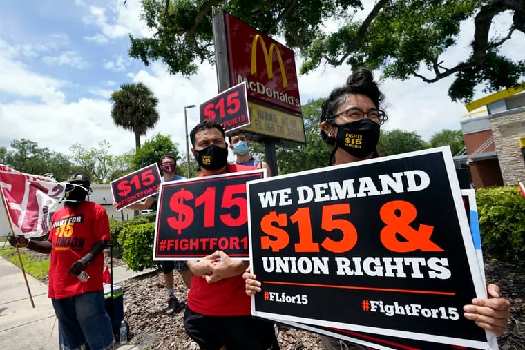 Workers and family members take part in a 15-city walkout to demand $15hr wages Wednesday, May 19, 2021, in front of a McDonald's restaurant in Sanford, Fla.  From minimum wage increases to animal protection to police accountability to both cutting and increasing taxes a series of new laws are taking effect across the country on Saturday, Jan. 1, 2022.
