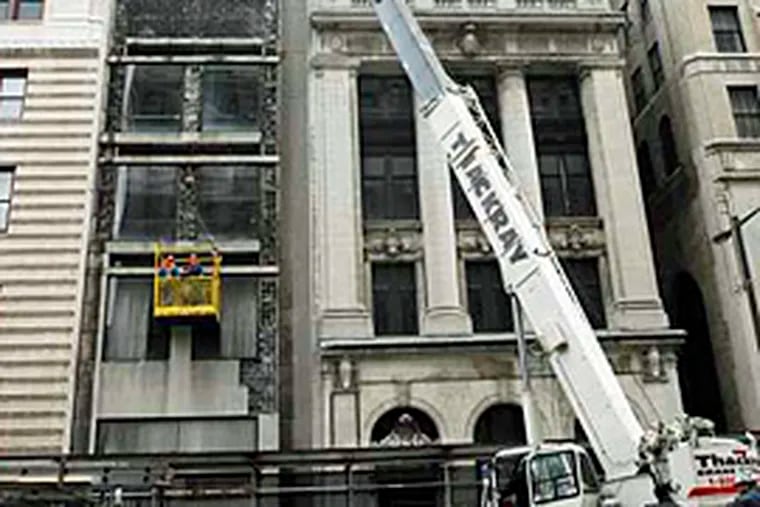 Contractors for the Convention Center Authority remove facade of a building on North Broad St. (Jonathan Wilson/Inquirer)