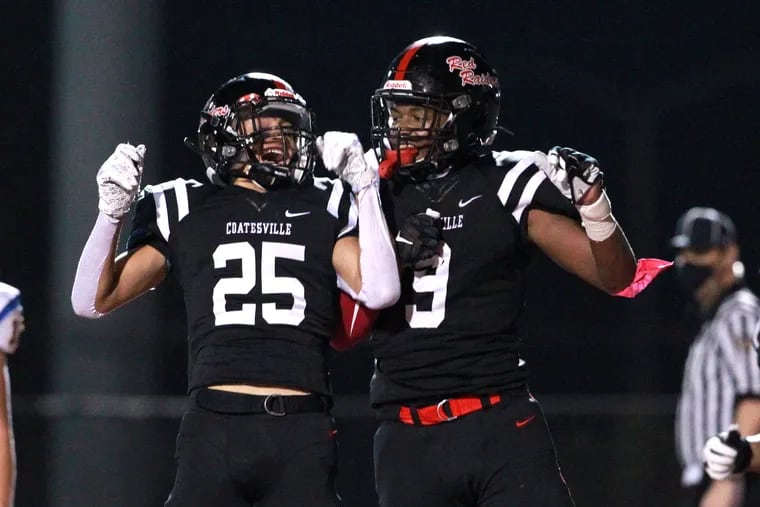 Abdul Sabur Stewart (right) of Coatesville celebrates with Deyon Moreno after Stewart’s touchdown catch on the final play of the first half against Downingtown East on Friday night.