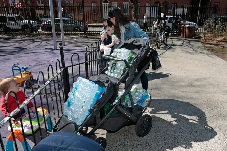 After loading up her stroller with several cases of water purchased at Acme on South Street, Julia Hershenberg greets her nephew at Seeger Park on Sunday.