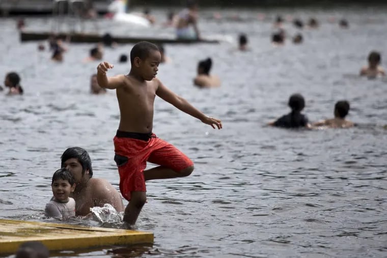 Amare Turner, 8, jumps off a dock and into Garrison Lake in Monroeville, NJ.