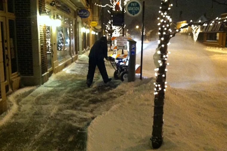Workers clear snow from a sidewalk in Collingswood early Friday morning. (Lissa Atkins/Philly.com)