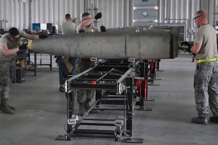 Members of a U.S. Air Force munitions team assemble guided bombs at the al-Udeid Air Base in Qatar to support the 379th Air Expeditionary Wing.