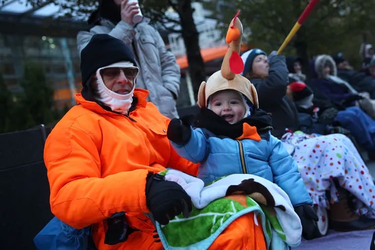 John Kerney, left, and his grandson Lincoln Kiessling, 2, of Barrington, N.J., watch the annual Thanksgiving Day parade in Center City Philadelphia on Thursday, Nov. 22, 2018. Temperatures were forecast to reach only into the 20s.