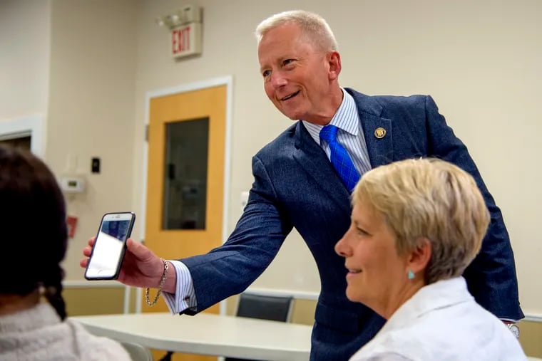 In this Inquirer file photo, Democratic primary candidate in New Jersey’s 2nd Congressional District, Jeff Van Drew shows voters a photo on his cell photo as he campaigns at the Linwood public library May 30, 2018.