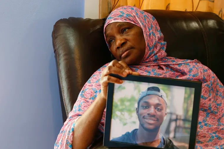 Manance Cisse holds a photo of her son Mouhamed Cisse in her West Philadelphia home. Mouhamed Cisse, 18, a talented cellist and drummer, was fatally shot about 12 a.m. Monday, June 1.